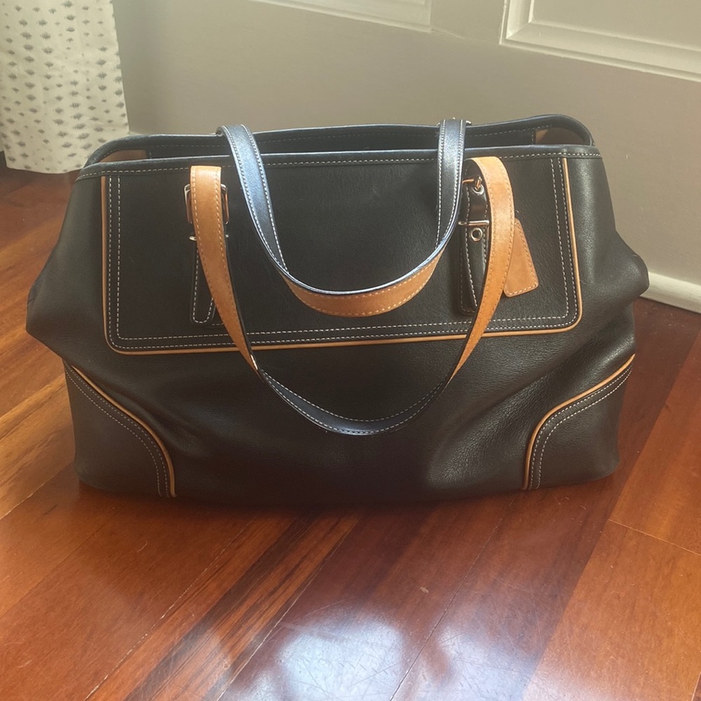 Coach bowling bag style.  Black and tan, silver hard wear.